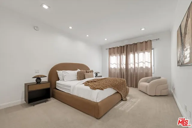 a spacious bedroom with a bed and a chandelier