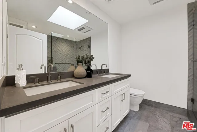 a bathroom with double sink and a mirror