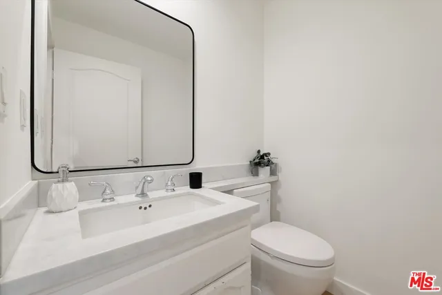a bathroom with a sink and mirror with toilet
