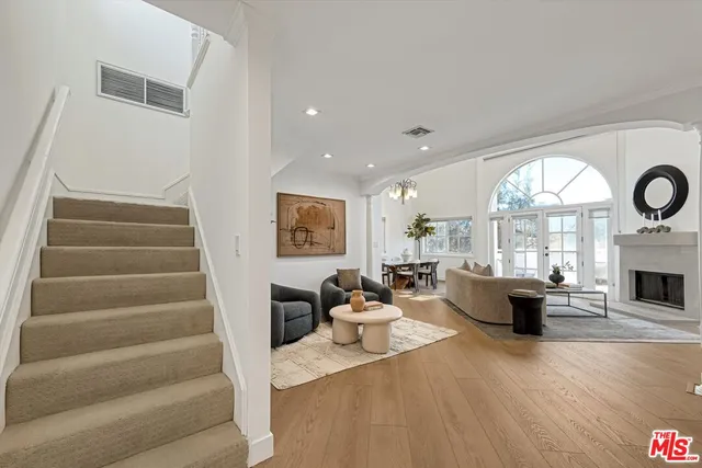 a living room with furniture a fireplace and a large window