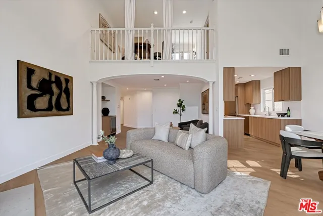 a living room with furniture and a view of kitchen