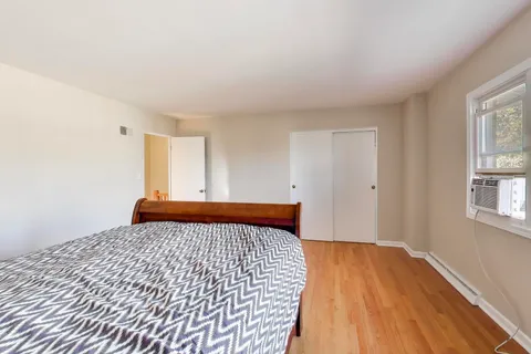 a bedroom with a bed and wooden floor