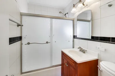 a bathroom with a sink mirror and a shower