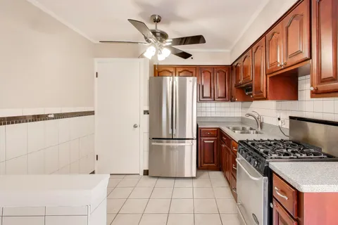 a kitchen with stainless steel appliances granite countertop a refrigerator a stove a sink and a refrigerator