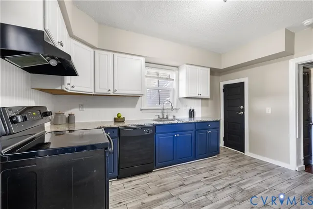 a kitchen with stainless steel appliances granite countertop a sink a window and cabinets