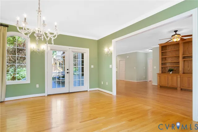 a view of an empty room with kitchen and window