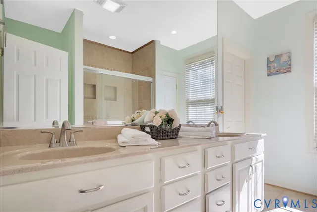 a bathroom with double vanity sinks and a mirror
