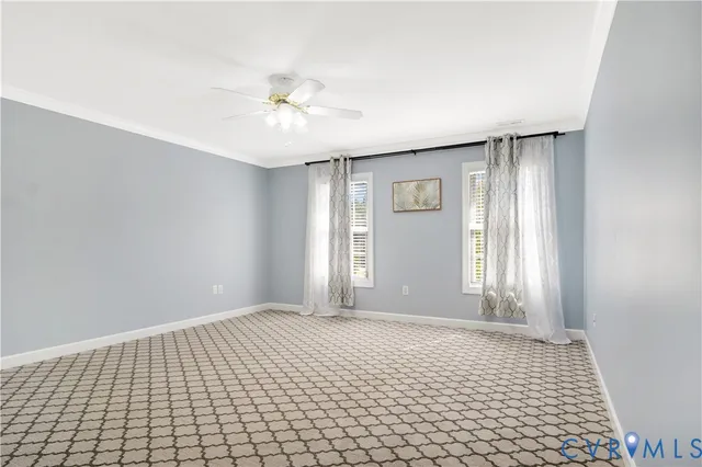 a view of an empty room with window and chandelier fan