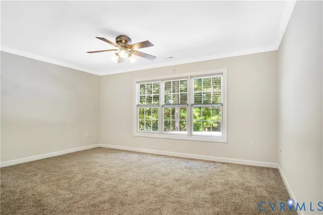 an empty room with windows and ceiling fan