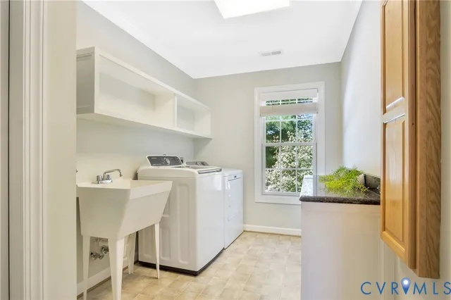 a utility room with cabinets washer and dryer