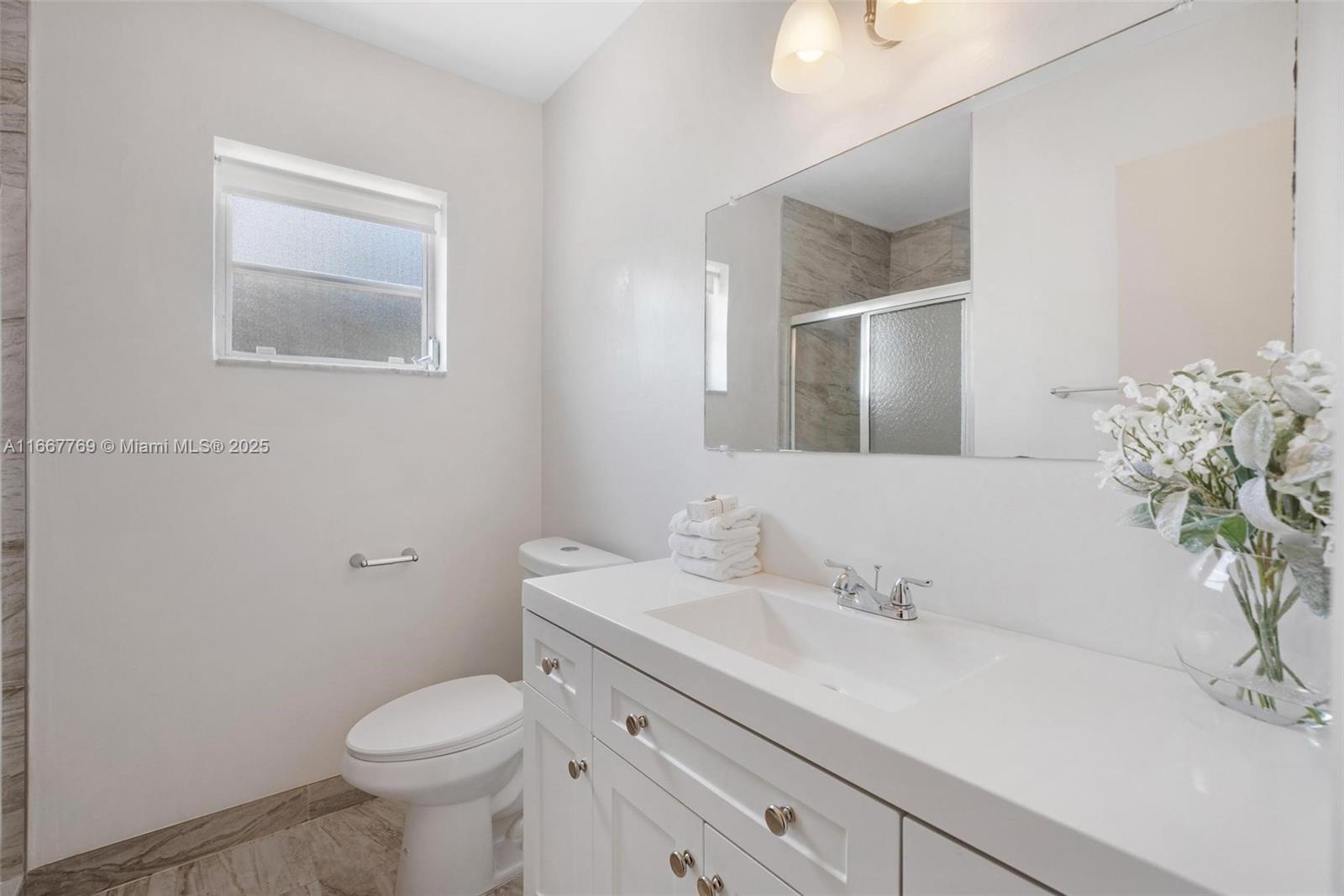 5300 Washington Street, Unit C111 Hollywood, FL 33021 - Photo 13 of 40 a bathroom with a sink a toilet and mirror