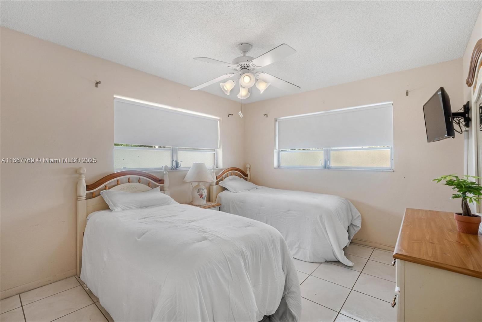 5300 Washington Street, Unit C111 Hollywood, FL 33021 - Photo 15 of 40 a bedroom with two beds and a chandelier
