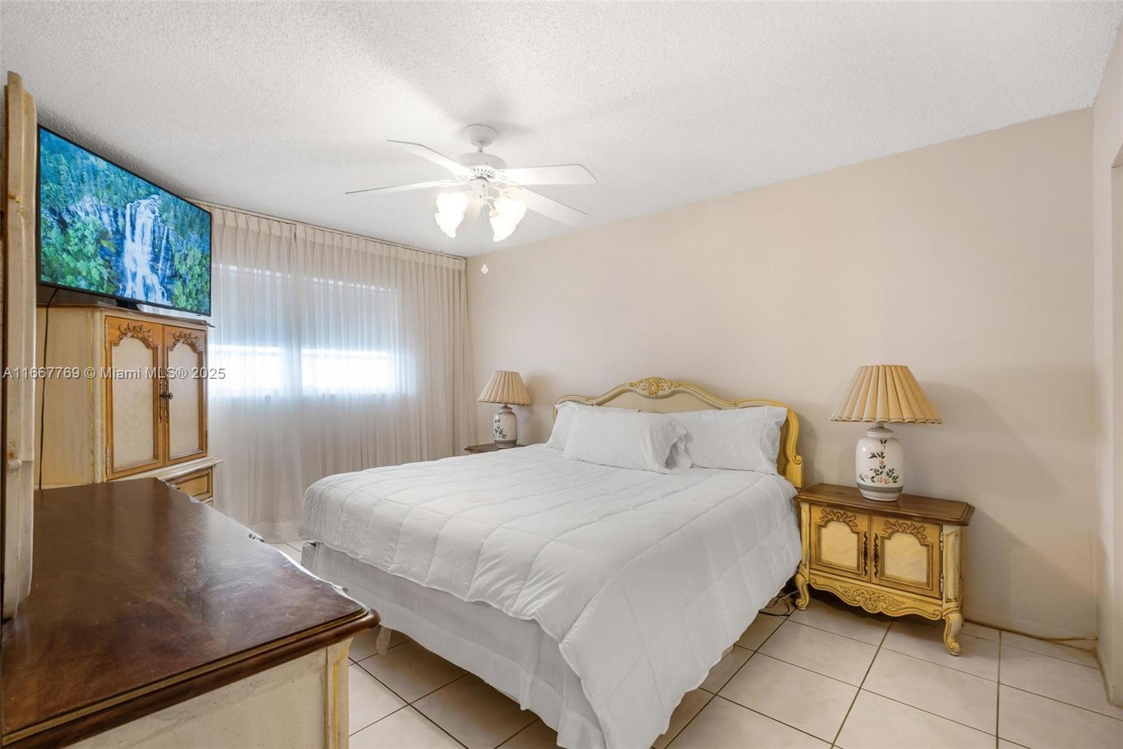 5300 Washington Street, Unit C111 Hollywood, FL 33021 - Photo 18 of 40 a bedroom with a bed and a chandelier