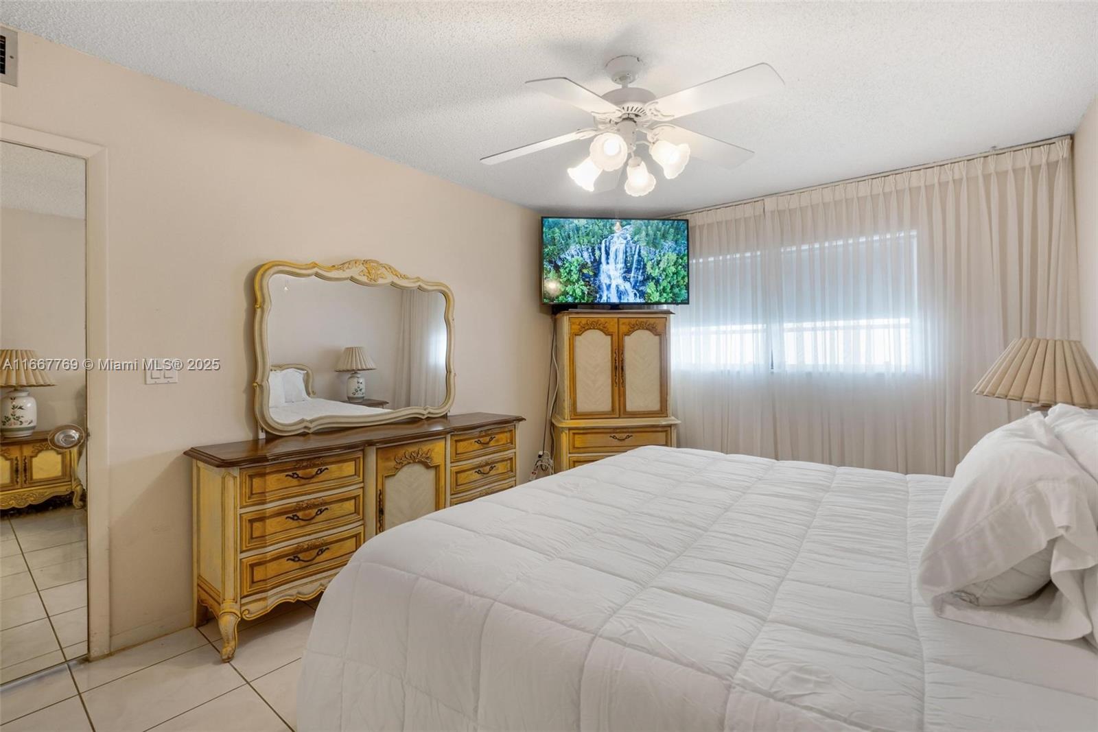 5300 Washington Street, Unit C111 Hollywood, FL 33021 - Photo 19 of 40 a bedroom with a bed and a chandelier on dresser