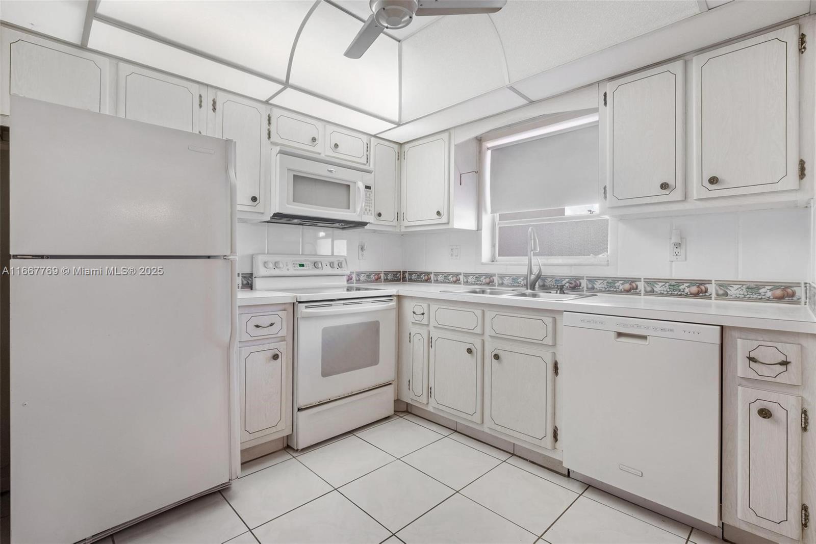 5300 Washington Street, Unit C111 Hollywood, FL 33021 - Photo 4 of 40 a kitchen with white cabinets and white appliances