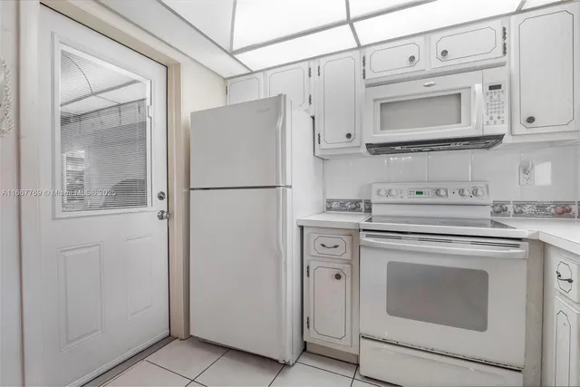 a white refrigerator freezer and a stove sitting inside of a kitchen