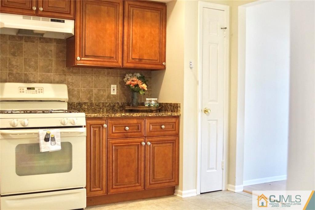 134 Redpine Loop Old Bridge, NJ 08857 - Photo 6 of 12 a kitchen with granite countertop cabinets and black appliances