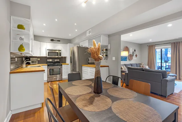 a kitchen with stainless steel appliances granite countertop sink stove refrigerator and cabinets