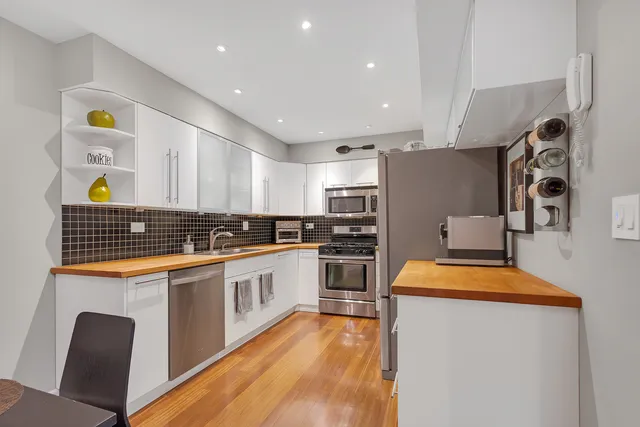 a kitchen with stainless steel appliances a stove a sink and a refrigerator