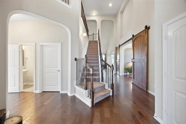 a view of a hallway with wooden floor and stairs