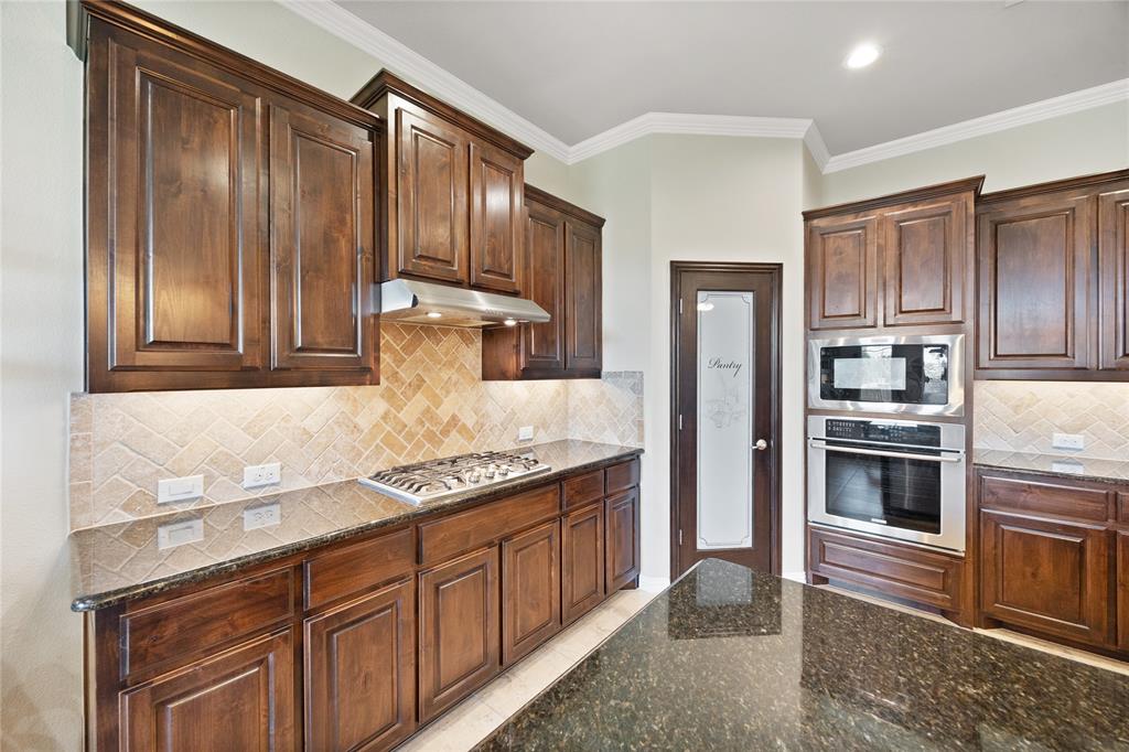 216 Equestrian Road Hickory Creek, TX 75065 - Photo 5 of 26 a kitchen with granite countertop stainless steel appliances and wooden cabinets