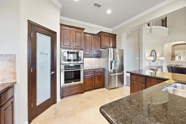 a kitchen with stainless steel appliances granite countertop a refrigerator and a sink