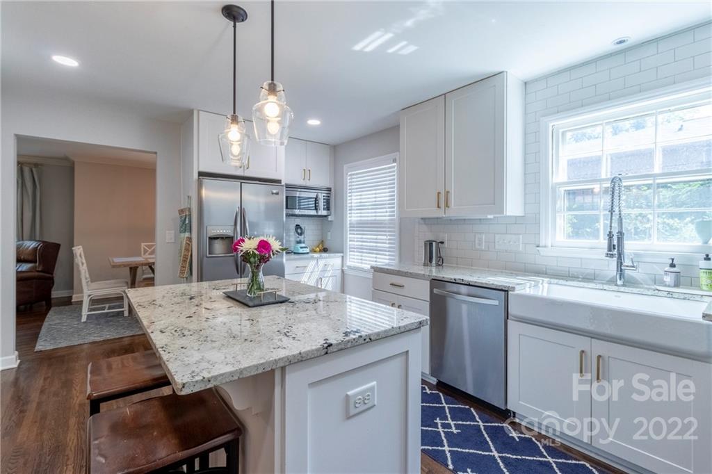 3722 Sulkirk Road Charlotte, NC 28210 - Photo 13 of 37 a kitchen with granite countertop kitchen island white cabinets stainless steel appliances dining table and chairs