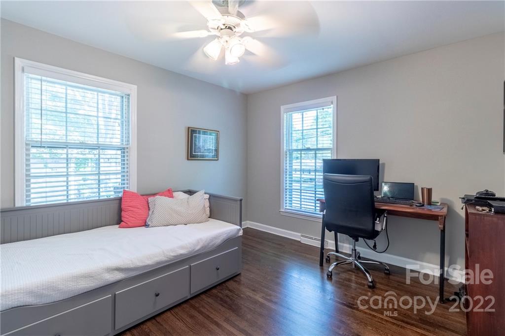 3722 Sulkirk Road Charlotte, NC 28210 - Photo 21 of 37 a bedroom with a bed a desk and chair with a bookshelf
