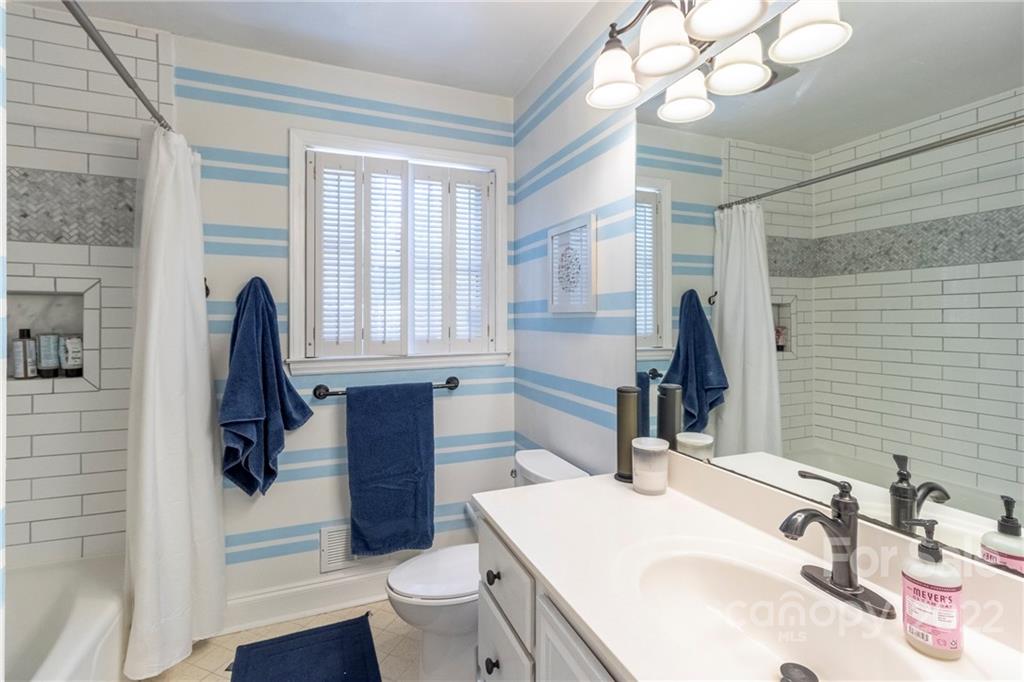 3722 Sulkirk Road Charlotte, NC 28210 - Photo 26 of 37 a bathroom with a sink a toilet a mirror and shower