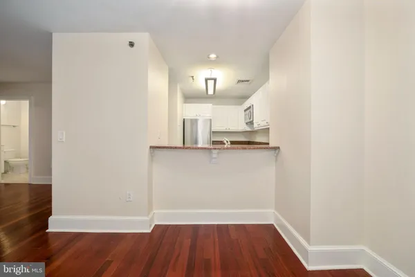 a view of a kitchen with wooden floor and electronic appliances