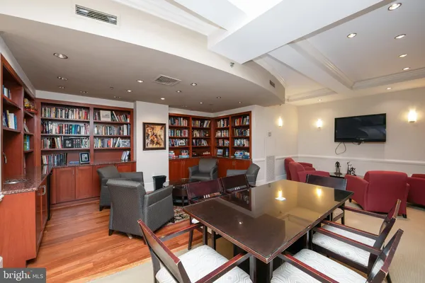 a living room with furniture a flat screen tv and bookshelf