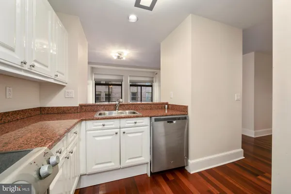 a kitchen with granite countertop a sink and cabinets