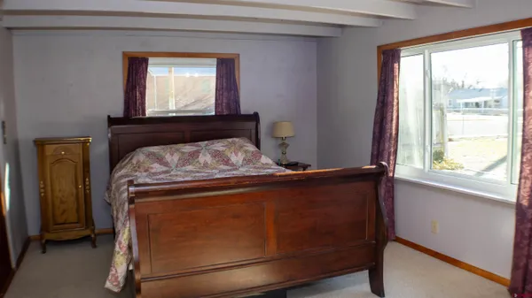 a bed sitting in a bedroom next to a window
