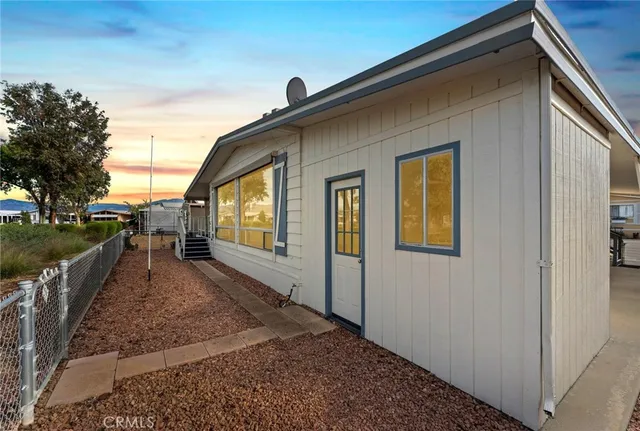 a view of a house with backyard and trees