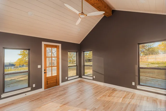 a big room with wooden floor and windows