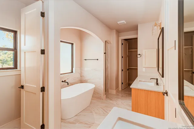 a spacious bathroom with a tub shower and sink