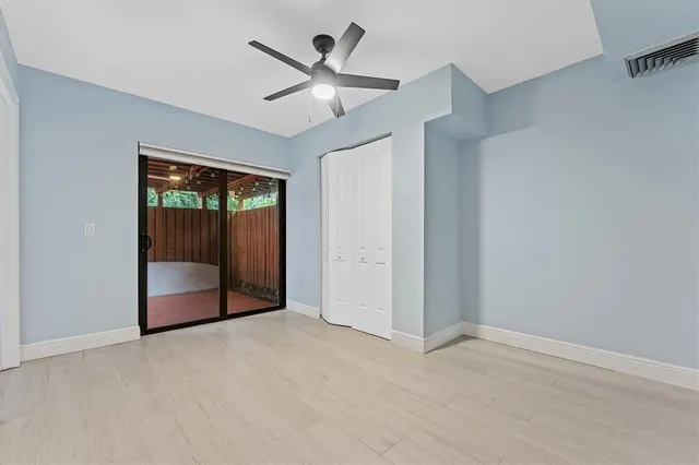 an empty room with fan and windows