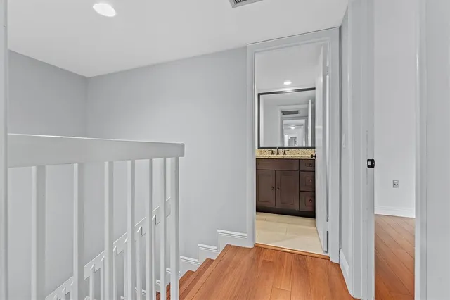 a view of a hallway with wooden floor and closet