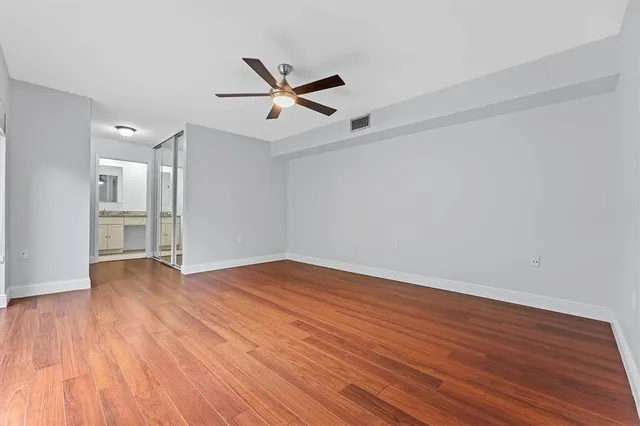 a view of empty room with wooden floor and window