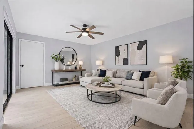 a living room with furniture a rug and a ceiling fan