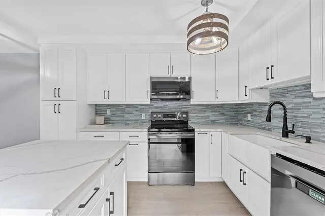 a kitchen with cabinets stainless steel appliances and a sink