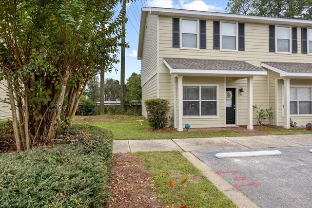 front view of a brick house with a yard