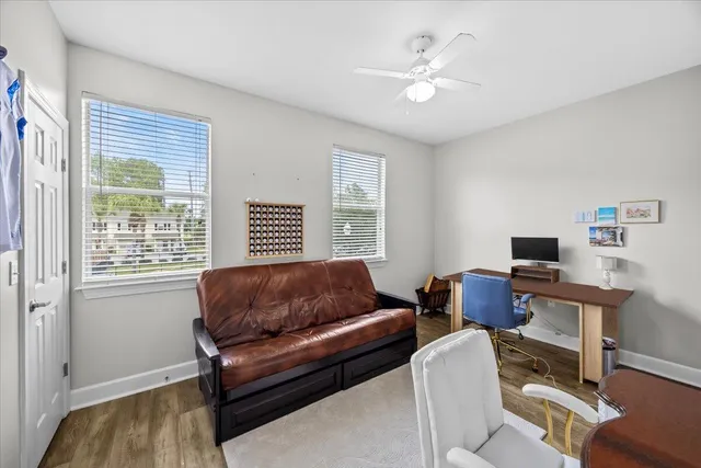 a living room with furniture ceiling fan and a window