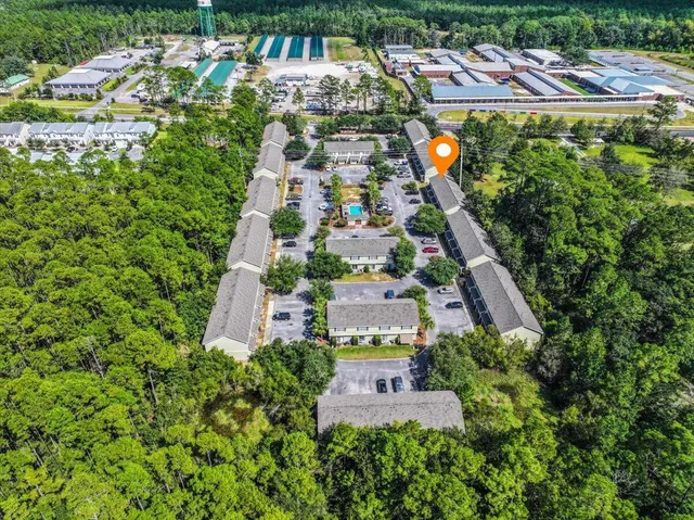 an aerial view of residential houses with outdoor space and trees all around