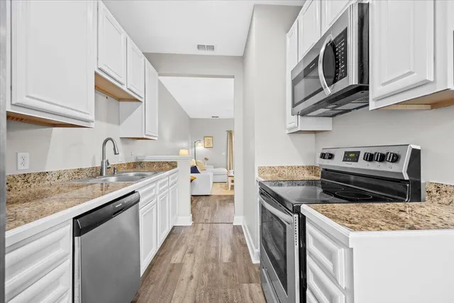 a kitchen with stainless steel appliances granite countertop a sink stove and cabinets