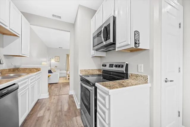 a kitchen with stainless steel appliances granite countertop a stove and a microwave