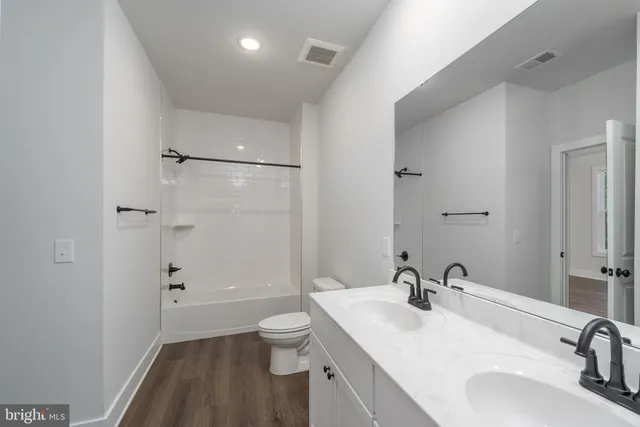 a bathroom with a shower tub sink and mirror