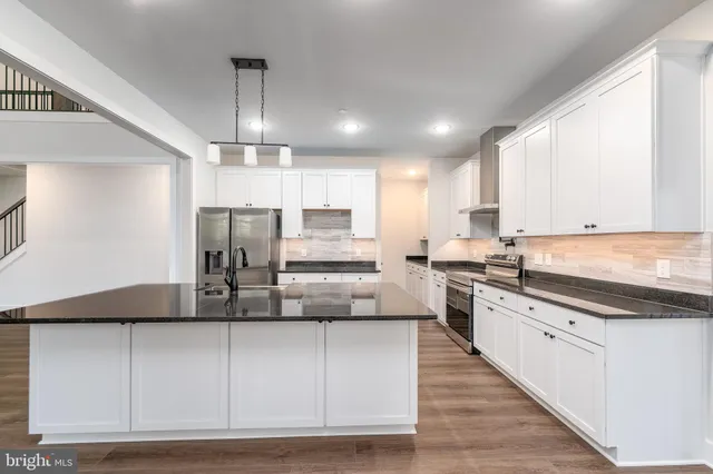 a kitchen with stainless steel appliances granite countertop a sink a stove and refrigerator