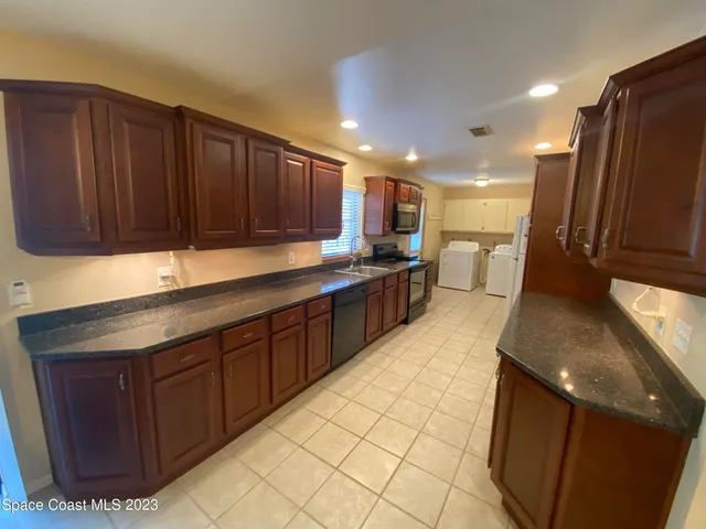 a kitchen with stainless steel appliances wooden cabinets a sink and a refrigerator