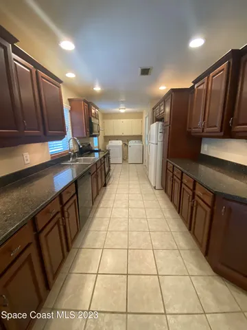 a kitchen with stainless steel appliances a sink a stove a refrigerator and cabinets